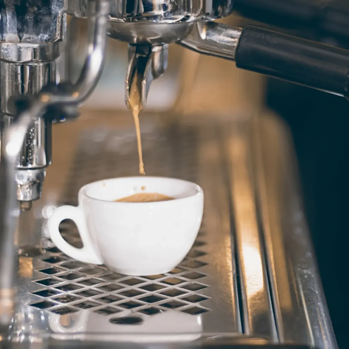 an espresso machine pouring coffee into a cup