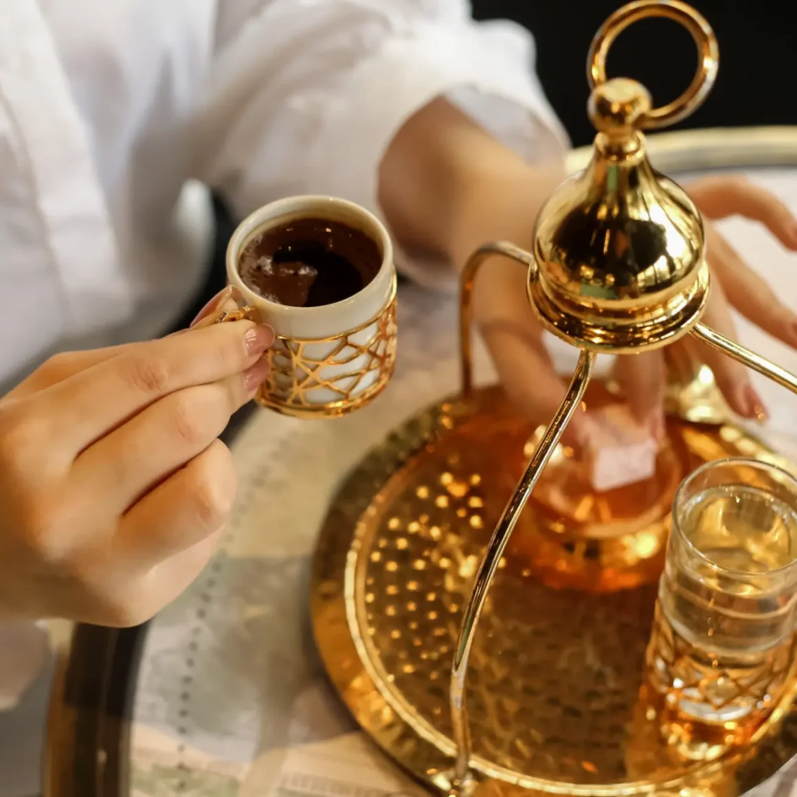 a person holding a cup of turkish coffee