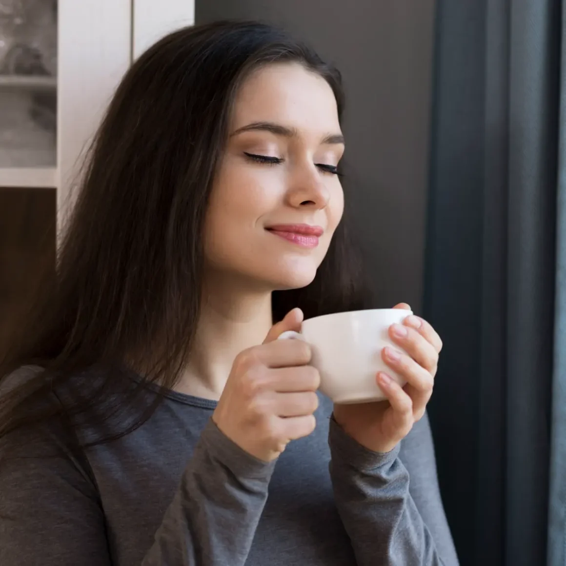 a woman holding a cup of decaf coffee