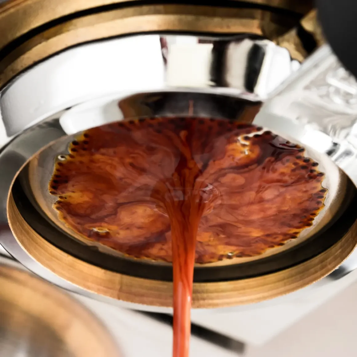 a close up of an espresso machine pulling a shot