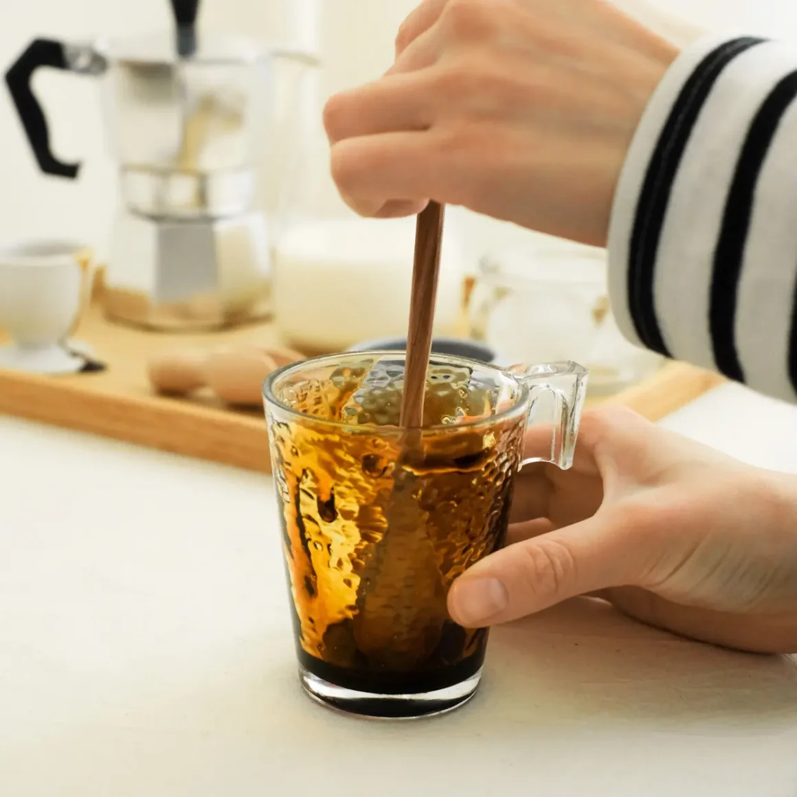 barista mixing syrup in a glass