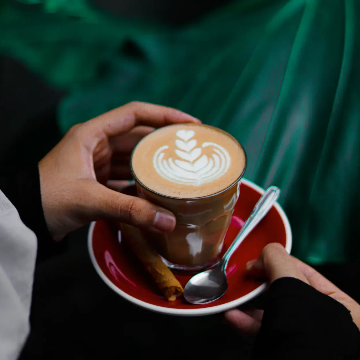 a person holding a cup of gibraltar coffee