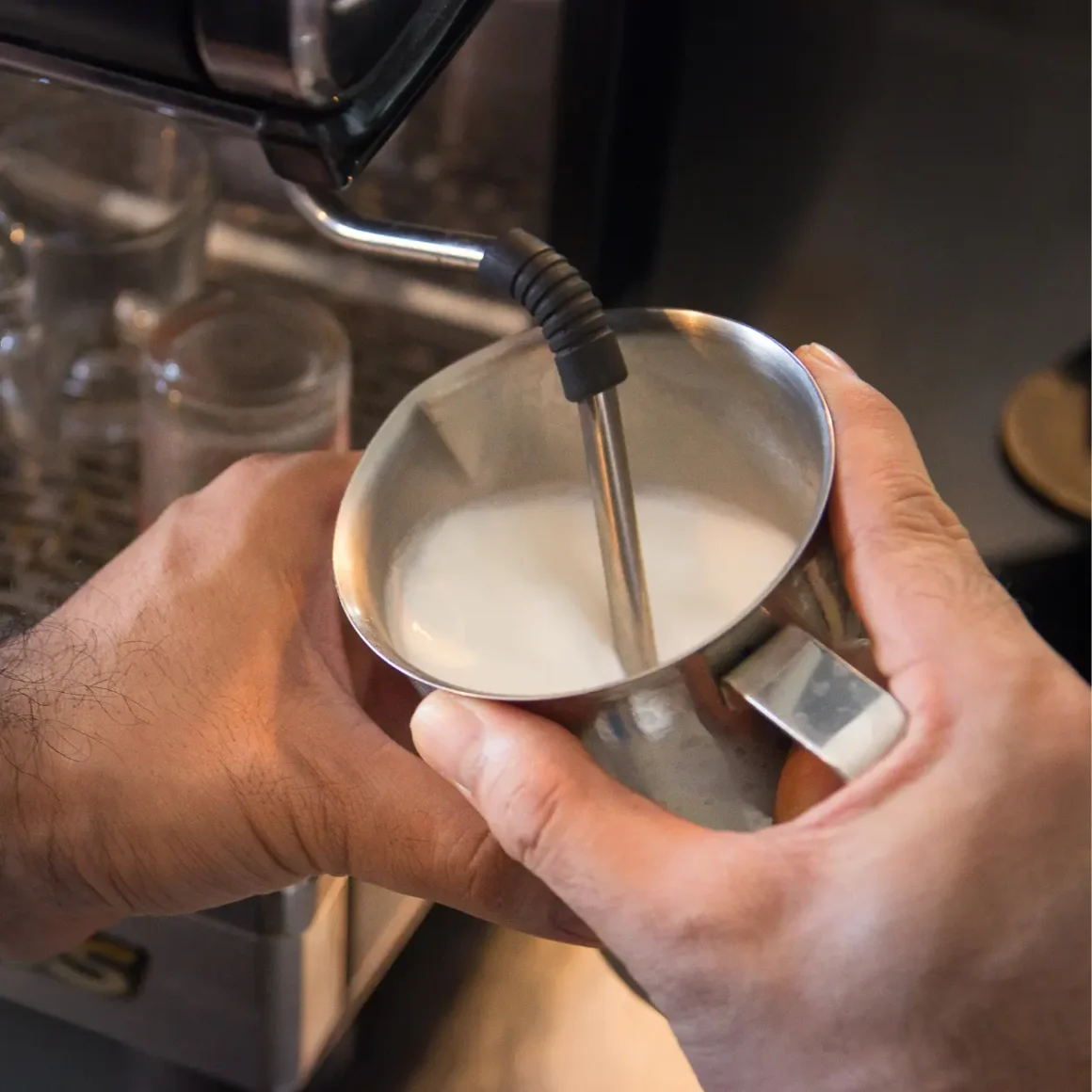 barista forthing milk into a cup