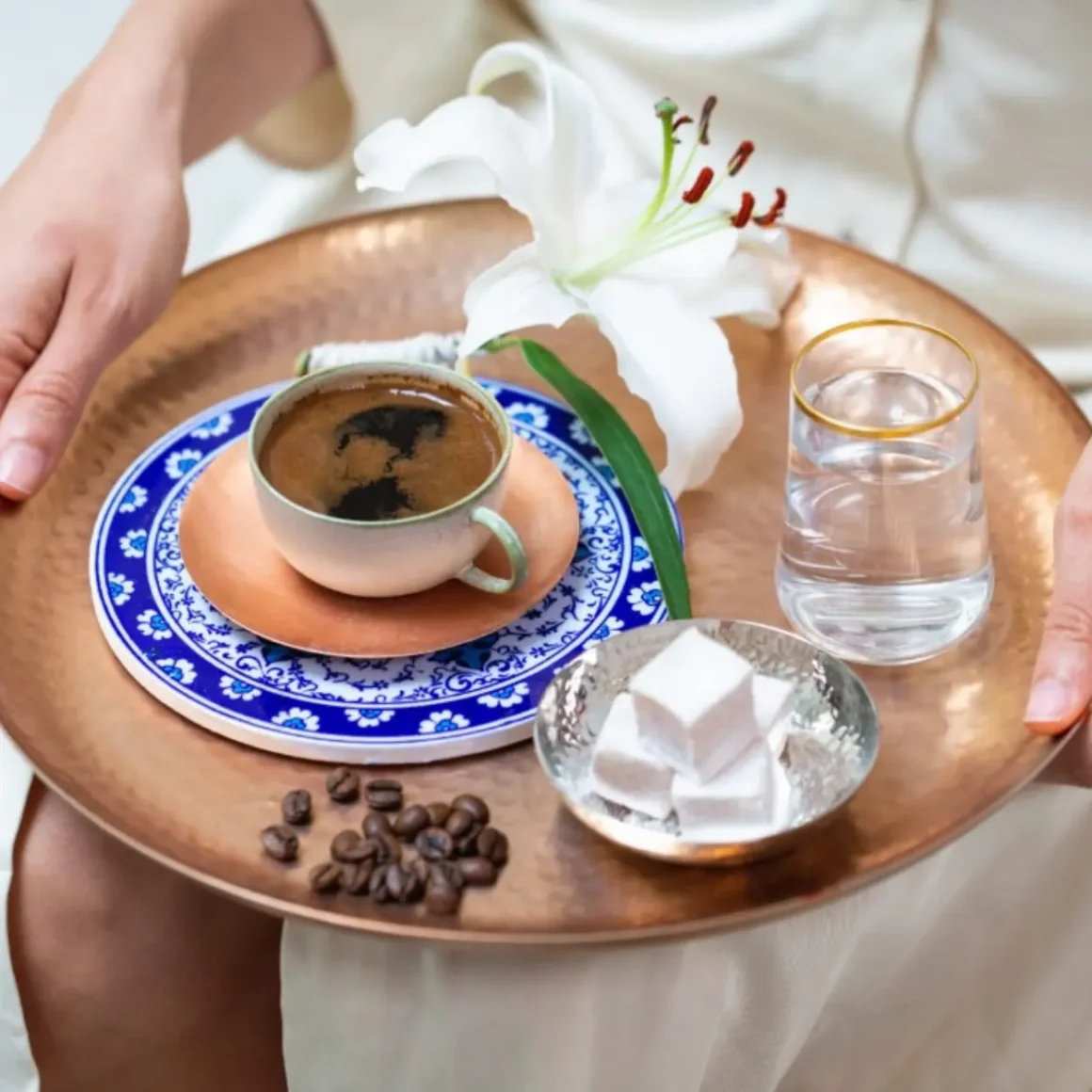 a tray with a cup of turkish coffee and a flower with turkish delight