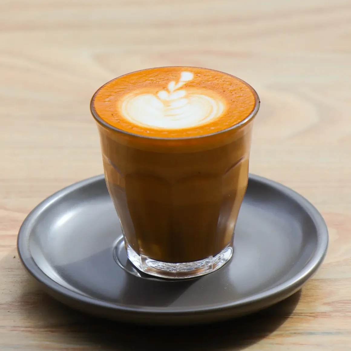 a cup of piccolo coffee on a plate