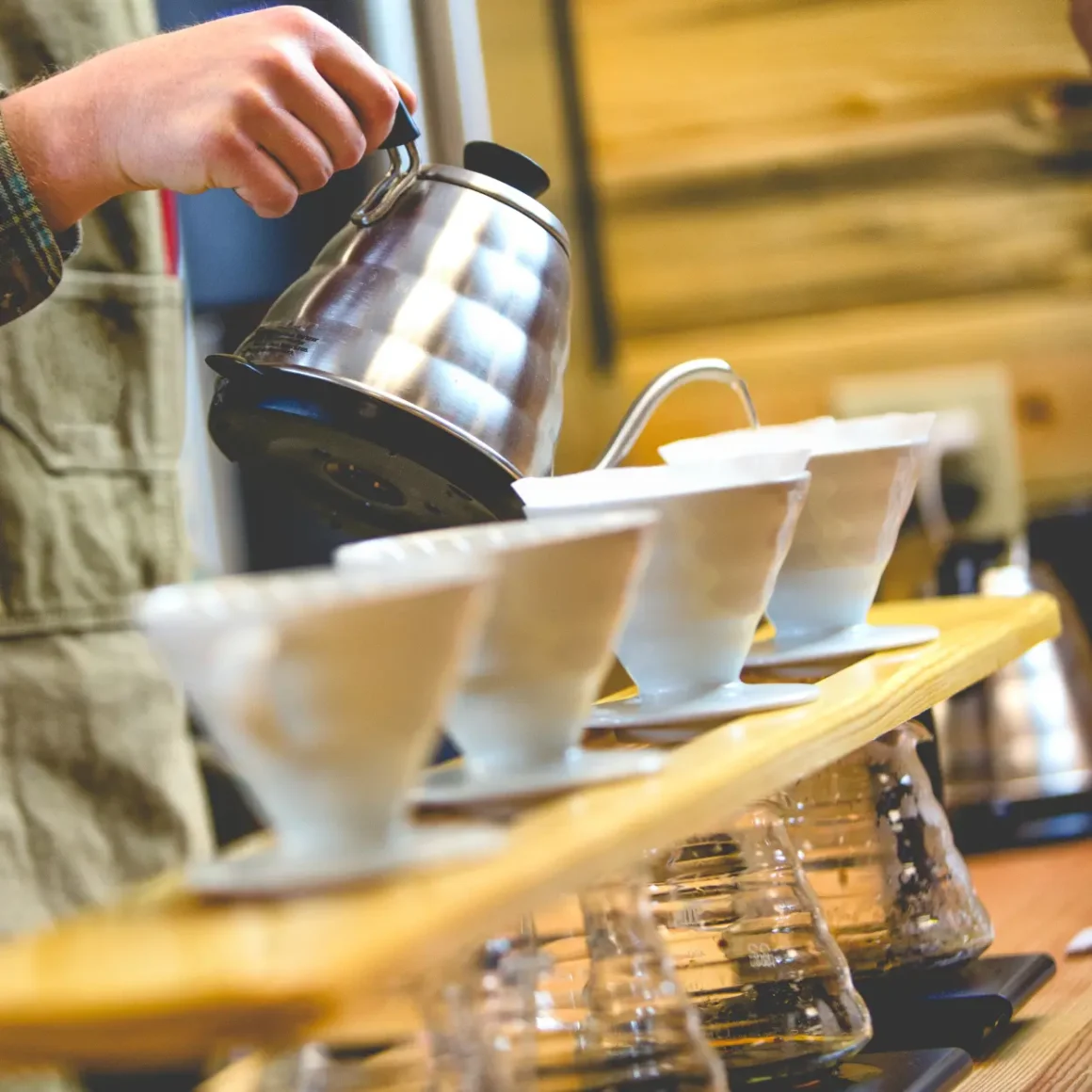 barista pouring coffee into cups