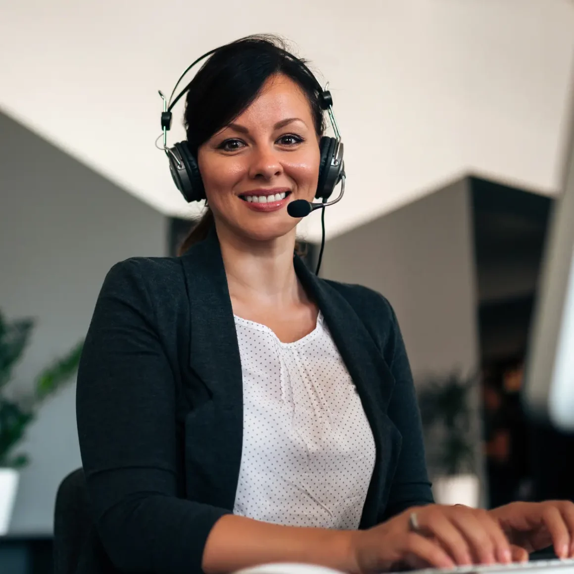 a woman wearing headphones and using a computer