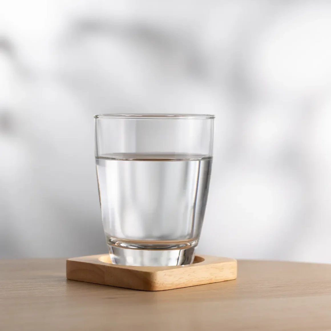a glass of water on a coaster
