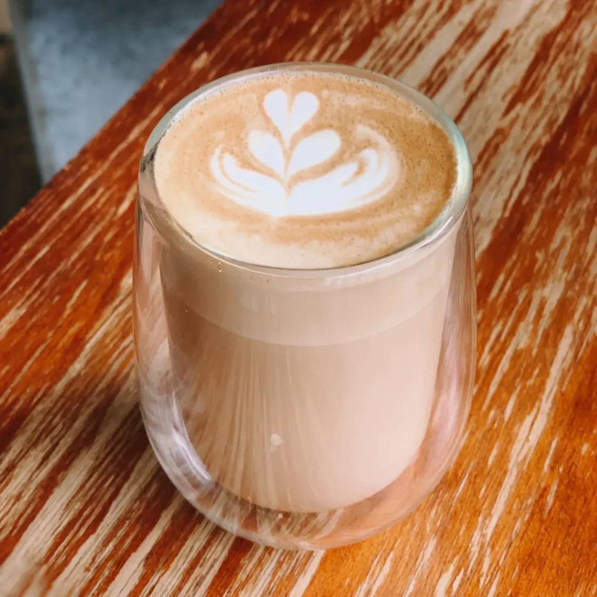 a glass cup of caffe misto with a leaf design on top