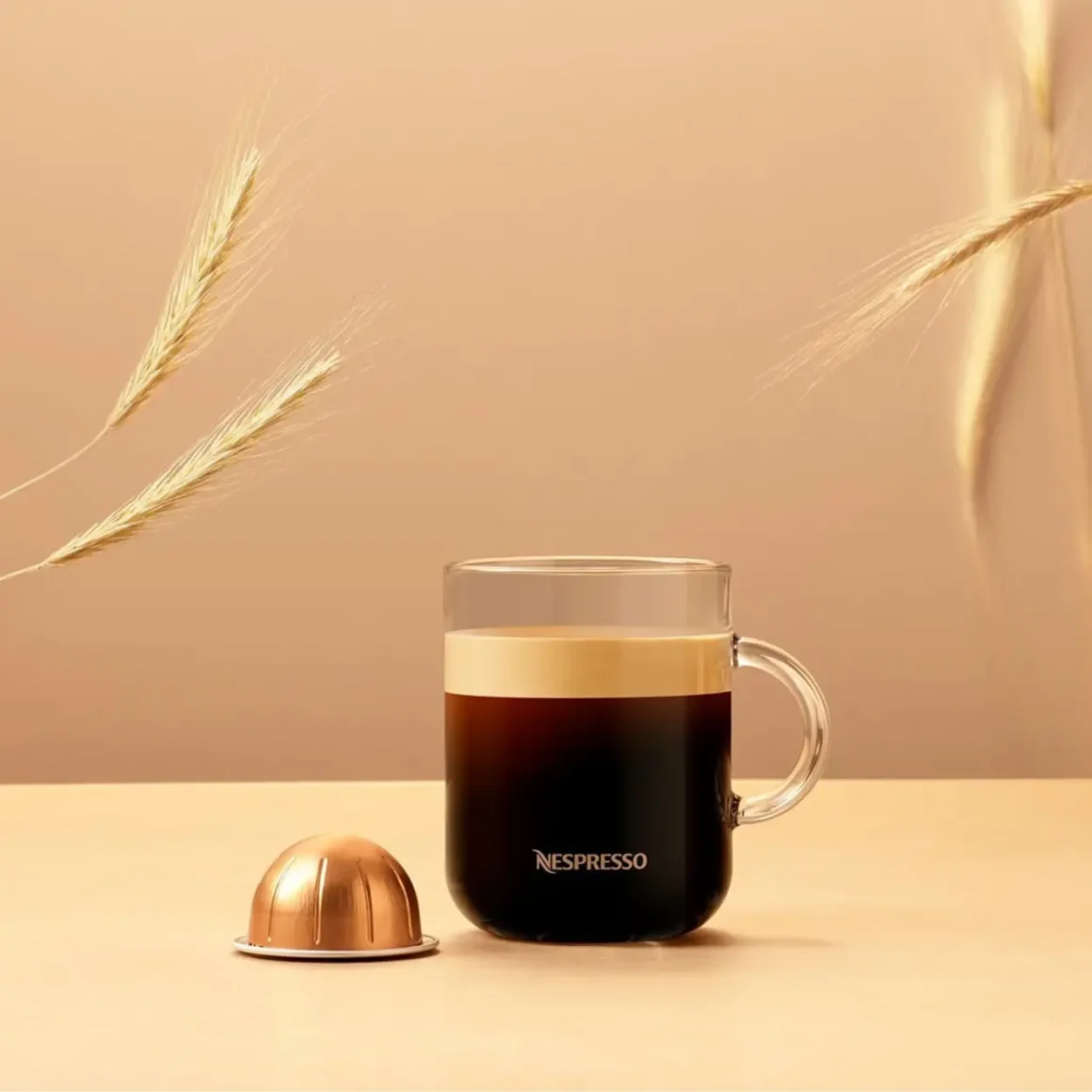 a glass cup of gran lungo coffee and a coffee capsule