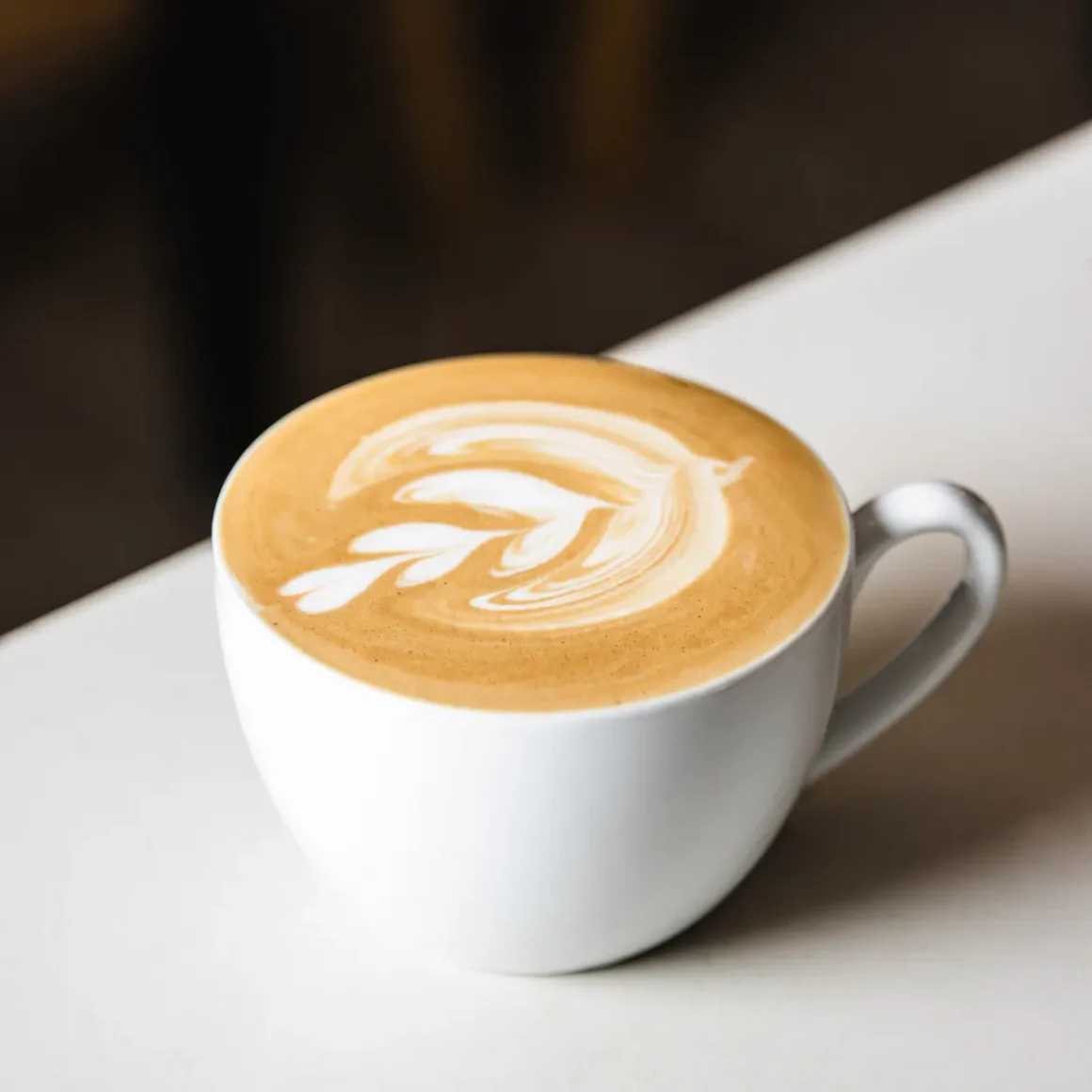 a cup of latte with a design in the foam