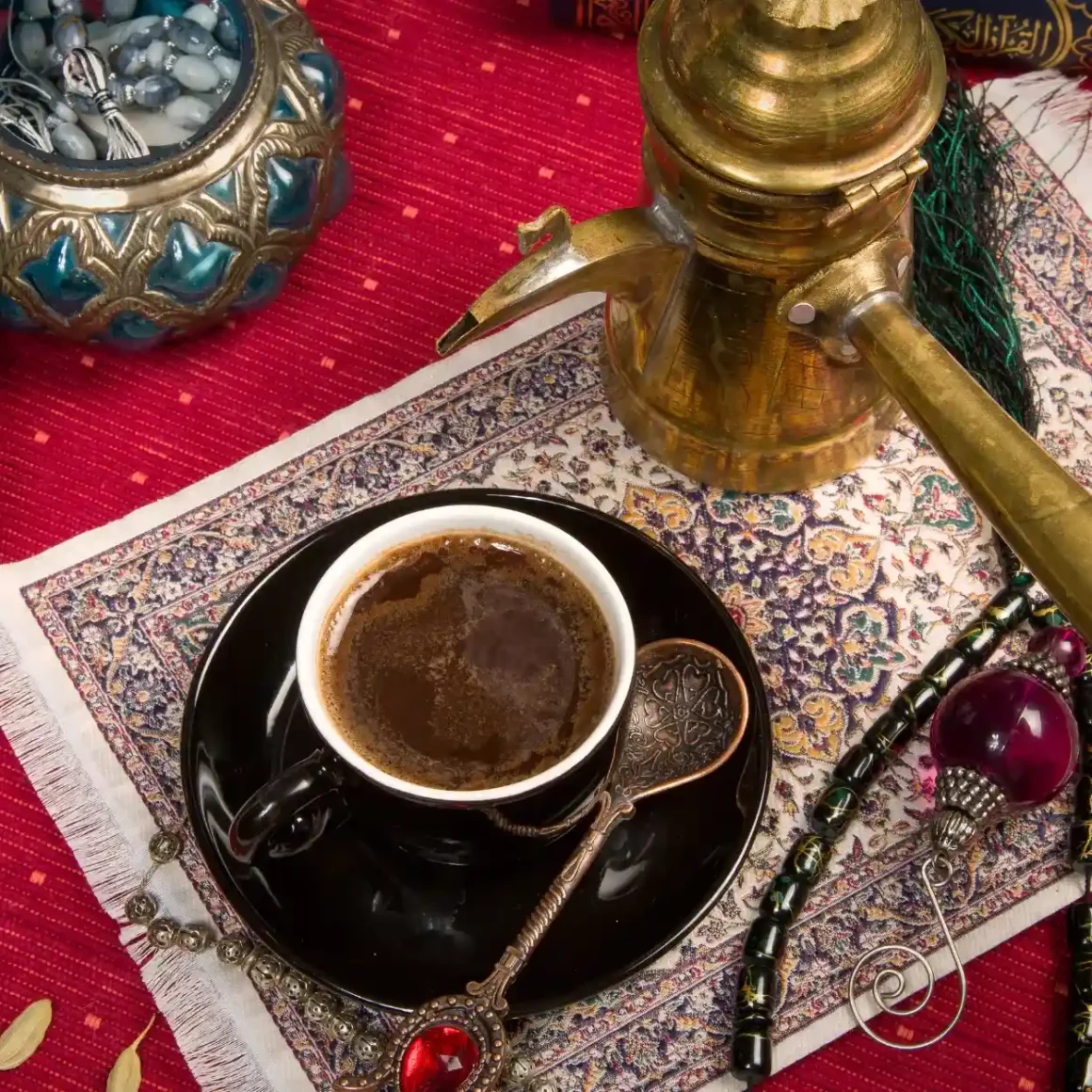 a cup of arabic coffee on a saucer with coffee pot