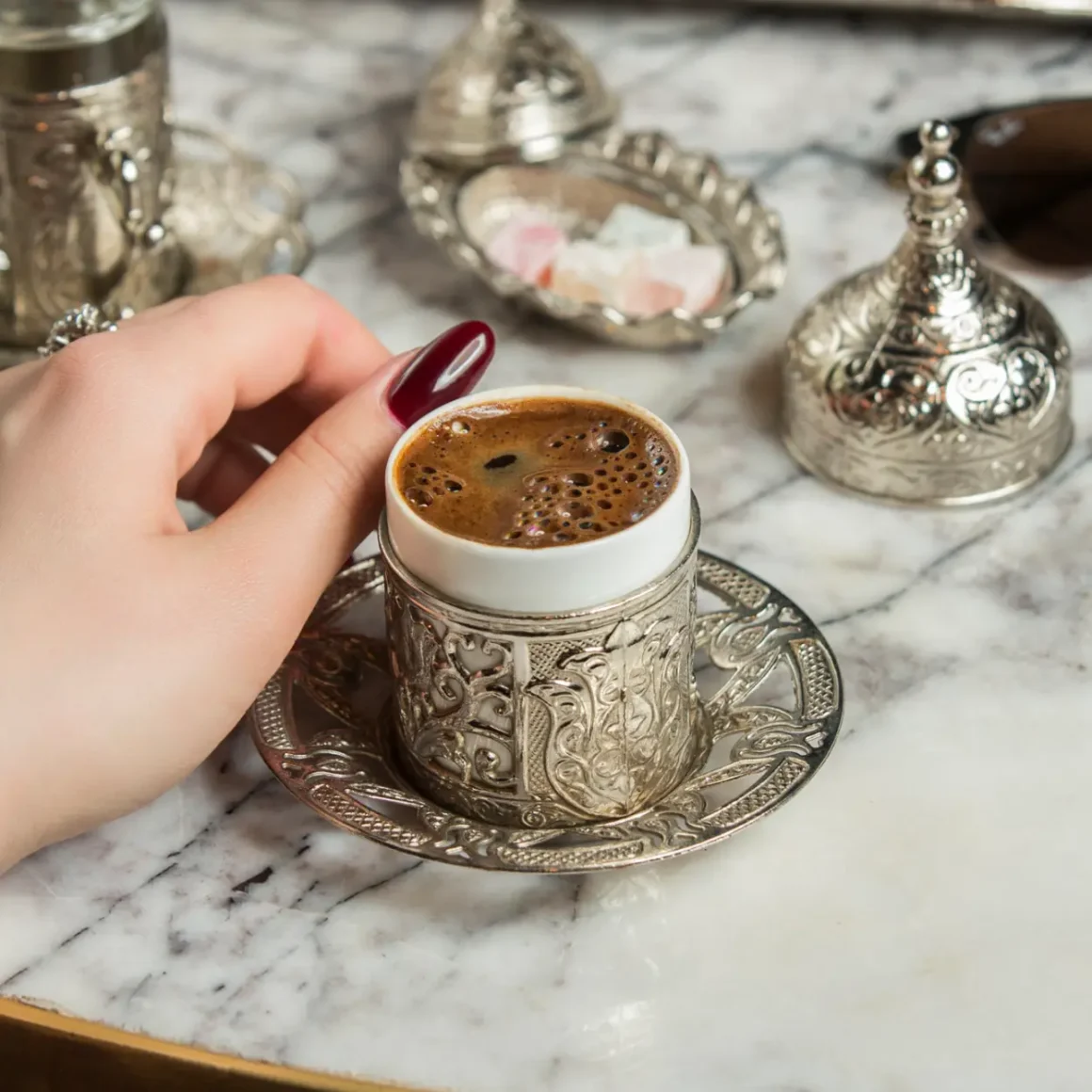 a hand holding a cup of turkish coffee