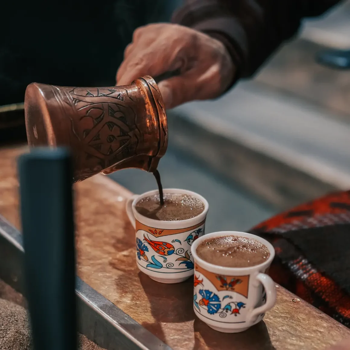 barista pouring turkish coffee into cups