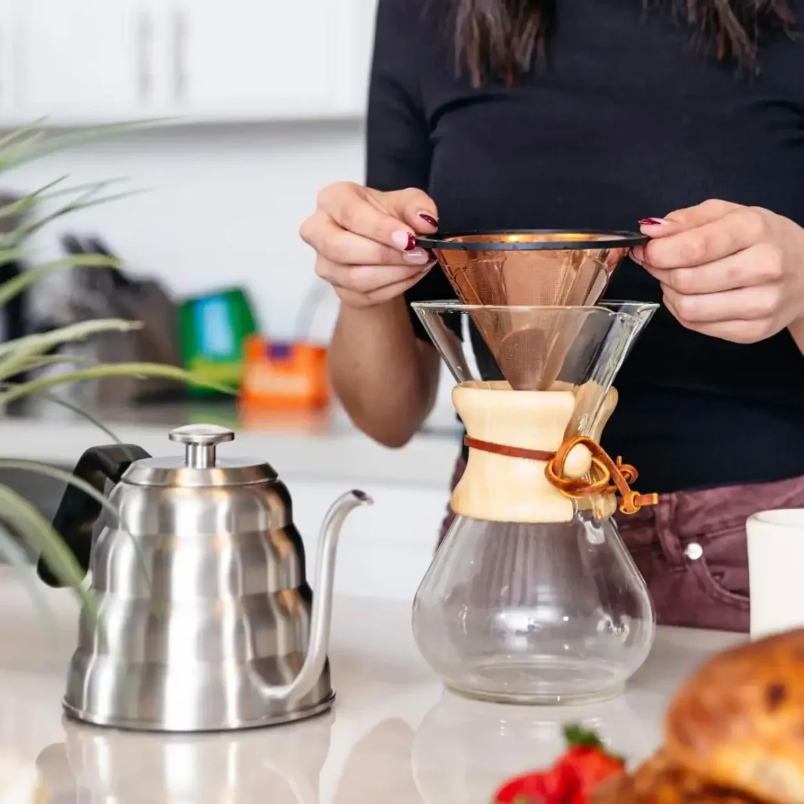 a person holding a barista warrior chemex reusable stainless steel pour over coffee filter