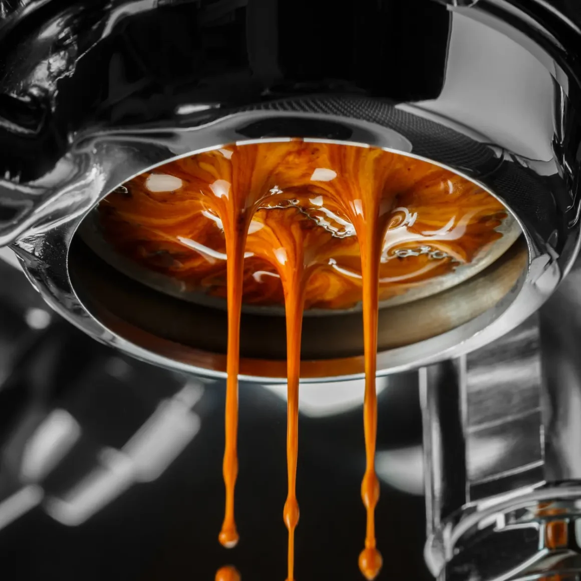 a close up of a bottomless portafilter in an espresso machine