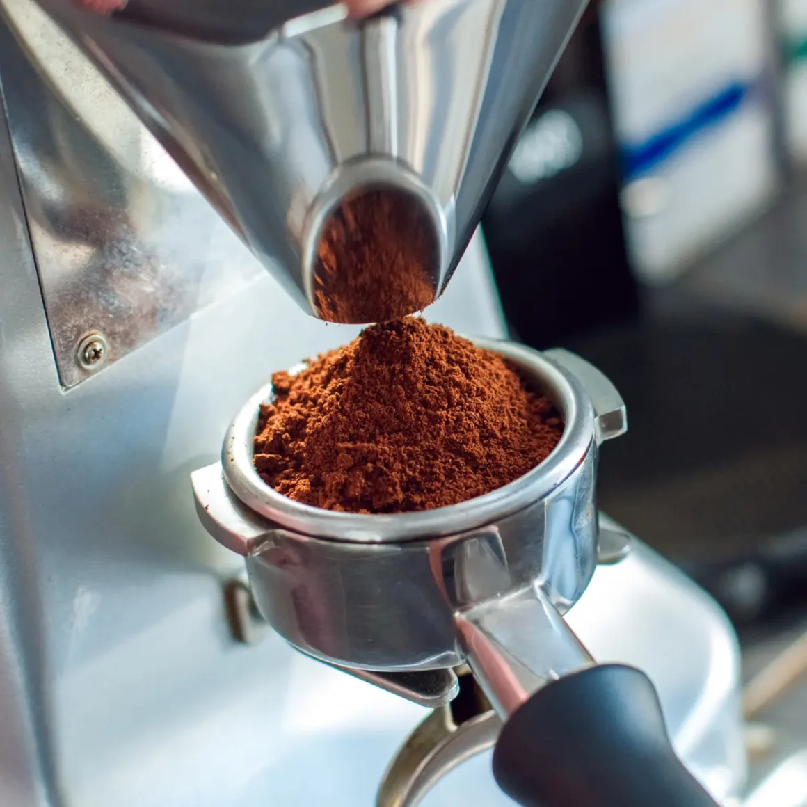 a coffee grinder with a pile of ground coffee in a portafilter