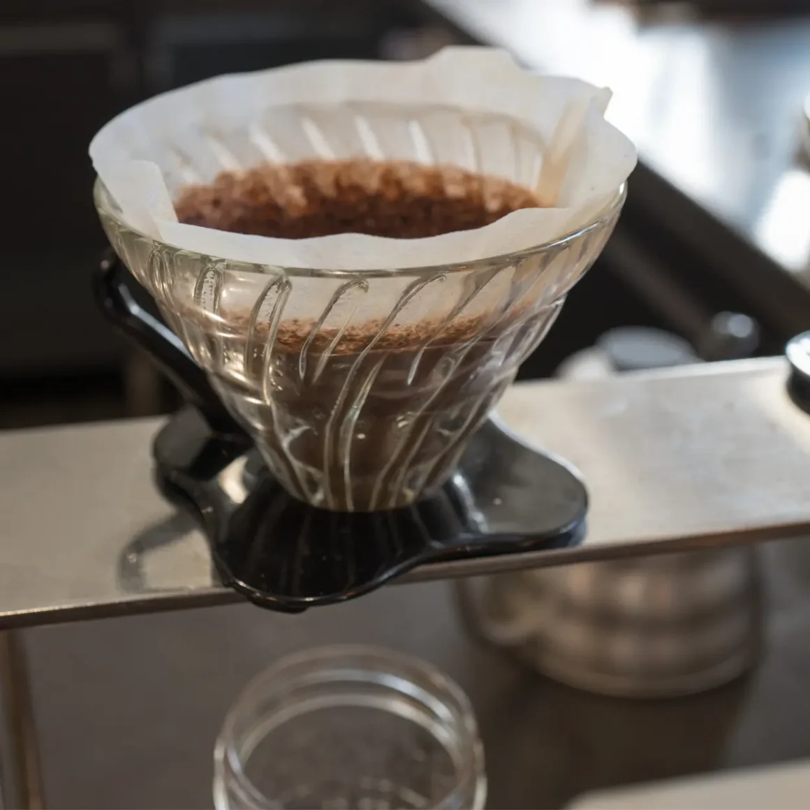 a glass coffee filter on a metal pour-over stand