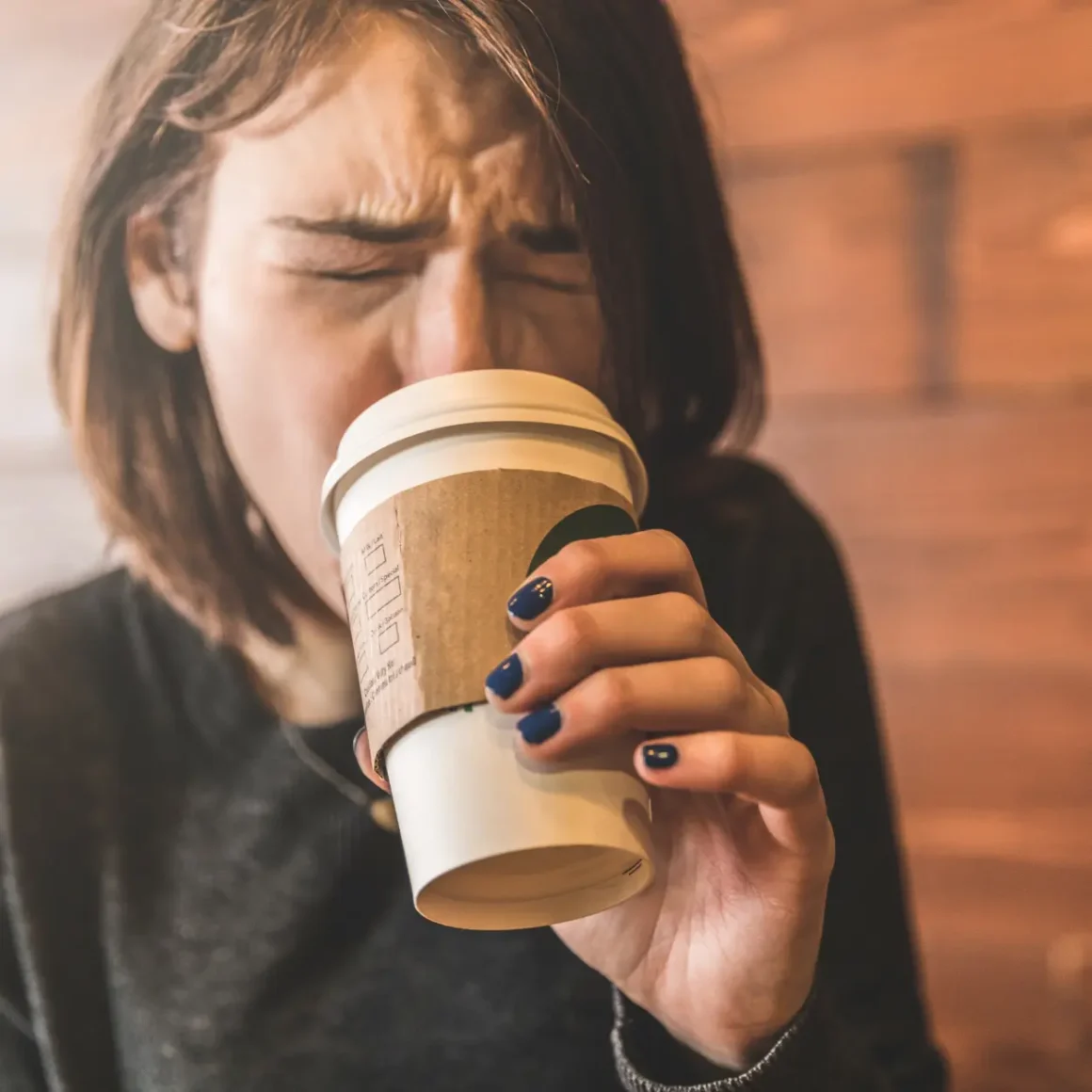 a woman drinking coffee from a cup