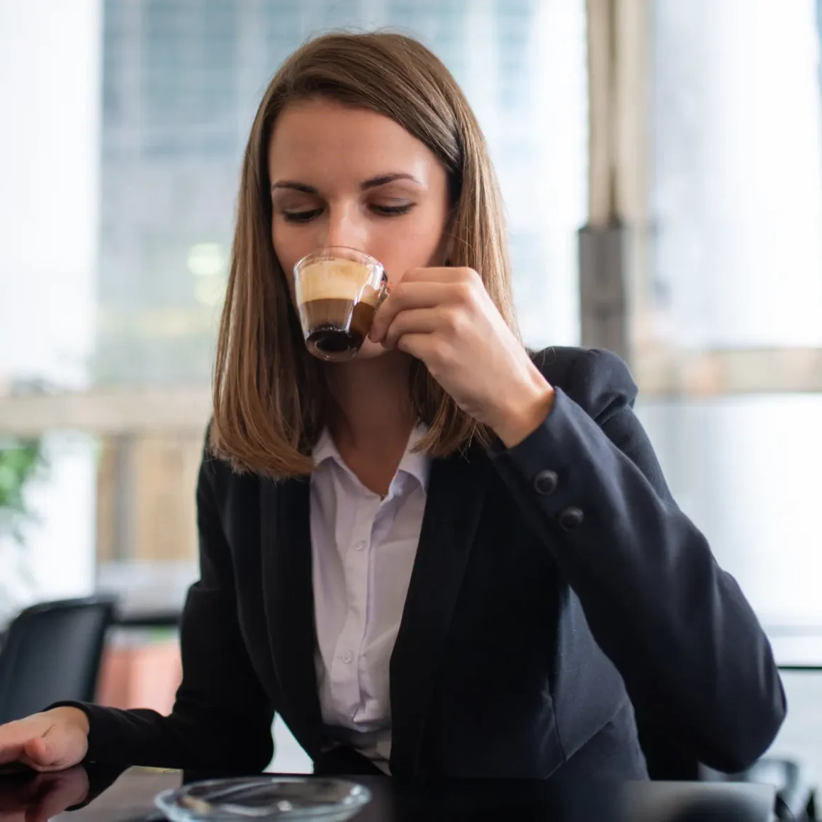 a woman drinking blonde espresso from a cup