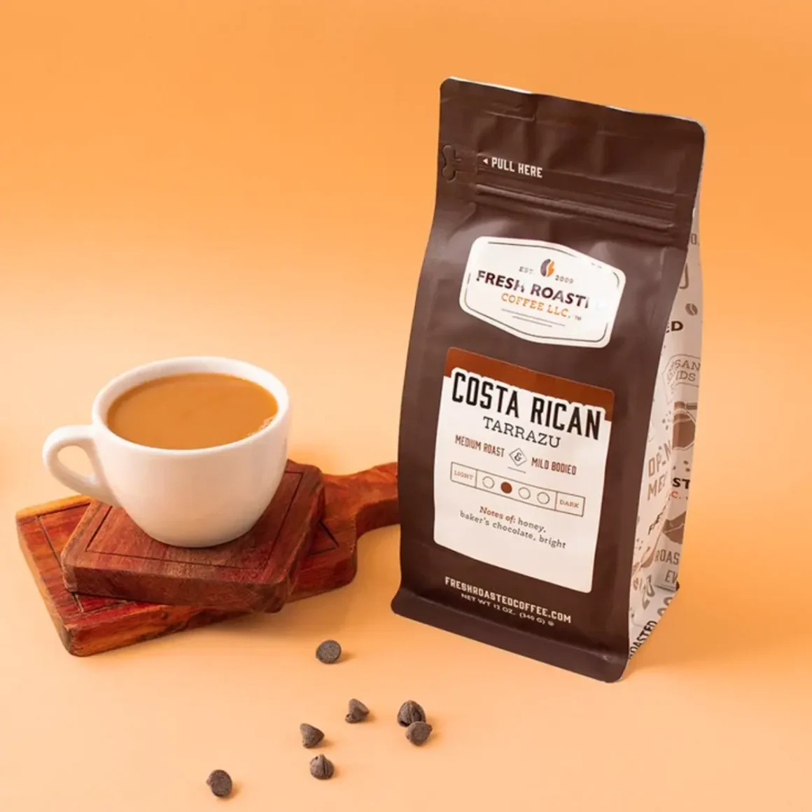 a bag of costa rican tarrazú coffee by fresh roasted coffee llc next to a cup of coffee
