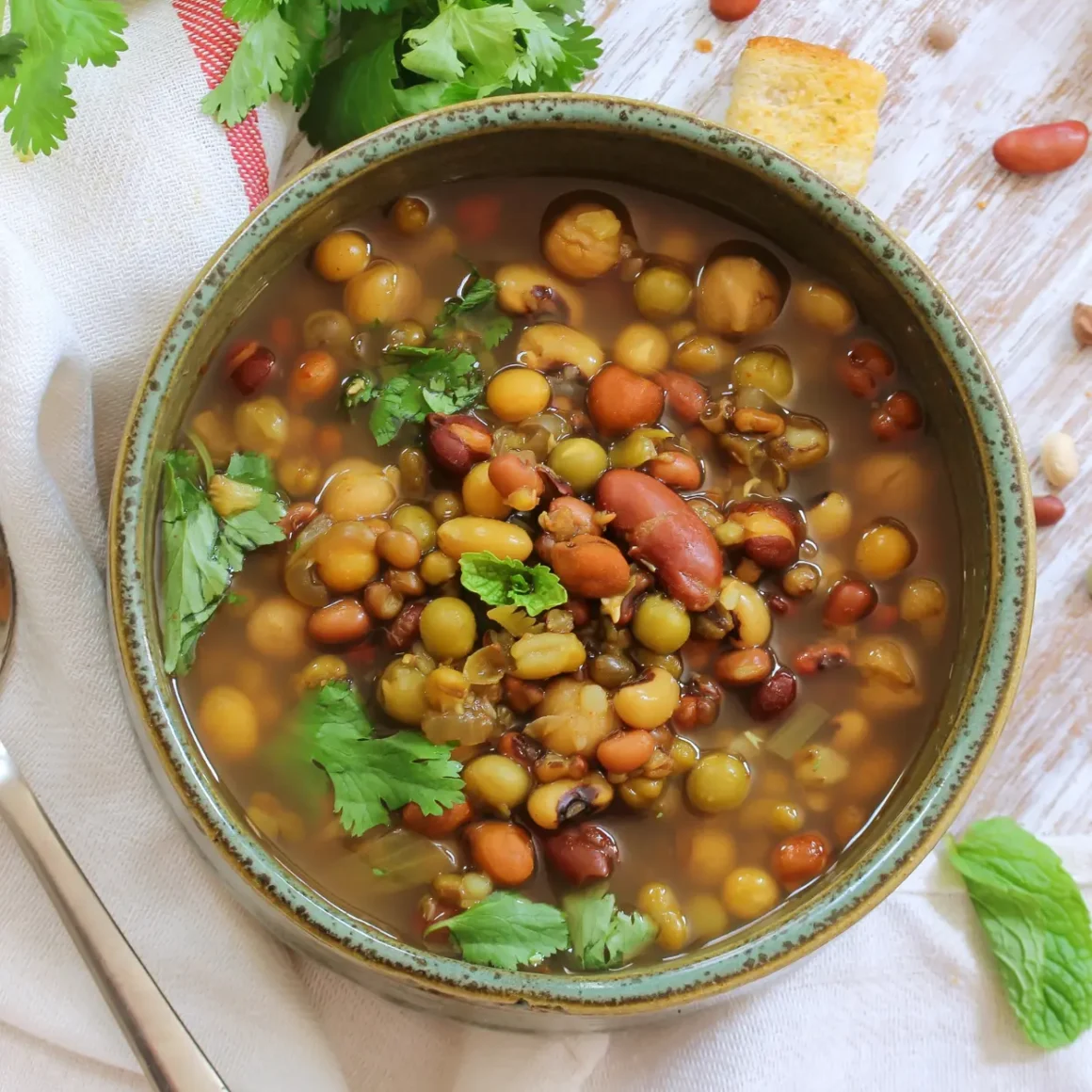 a bowl of soup with beans and parsley