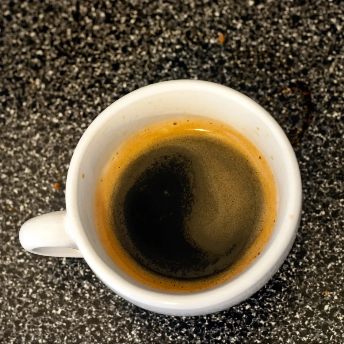 a cup of dead shot of espresso on a counter