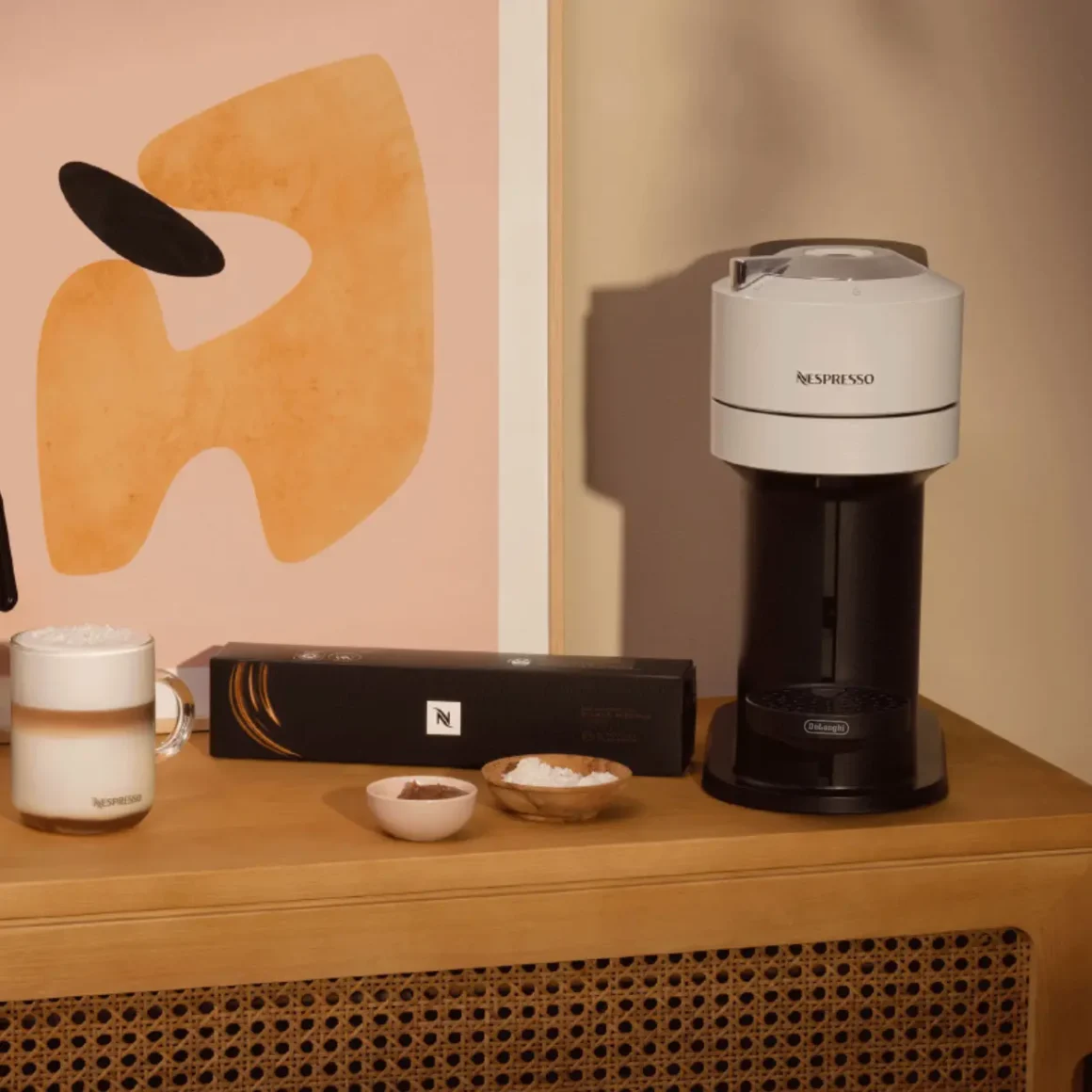 a nespresso vertuo next coffee machine and coffee cups on a table