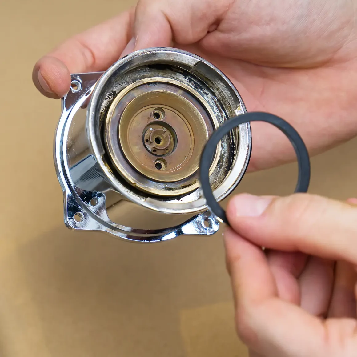 a person holding a round metal part of an espresso machine
