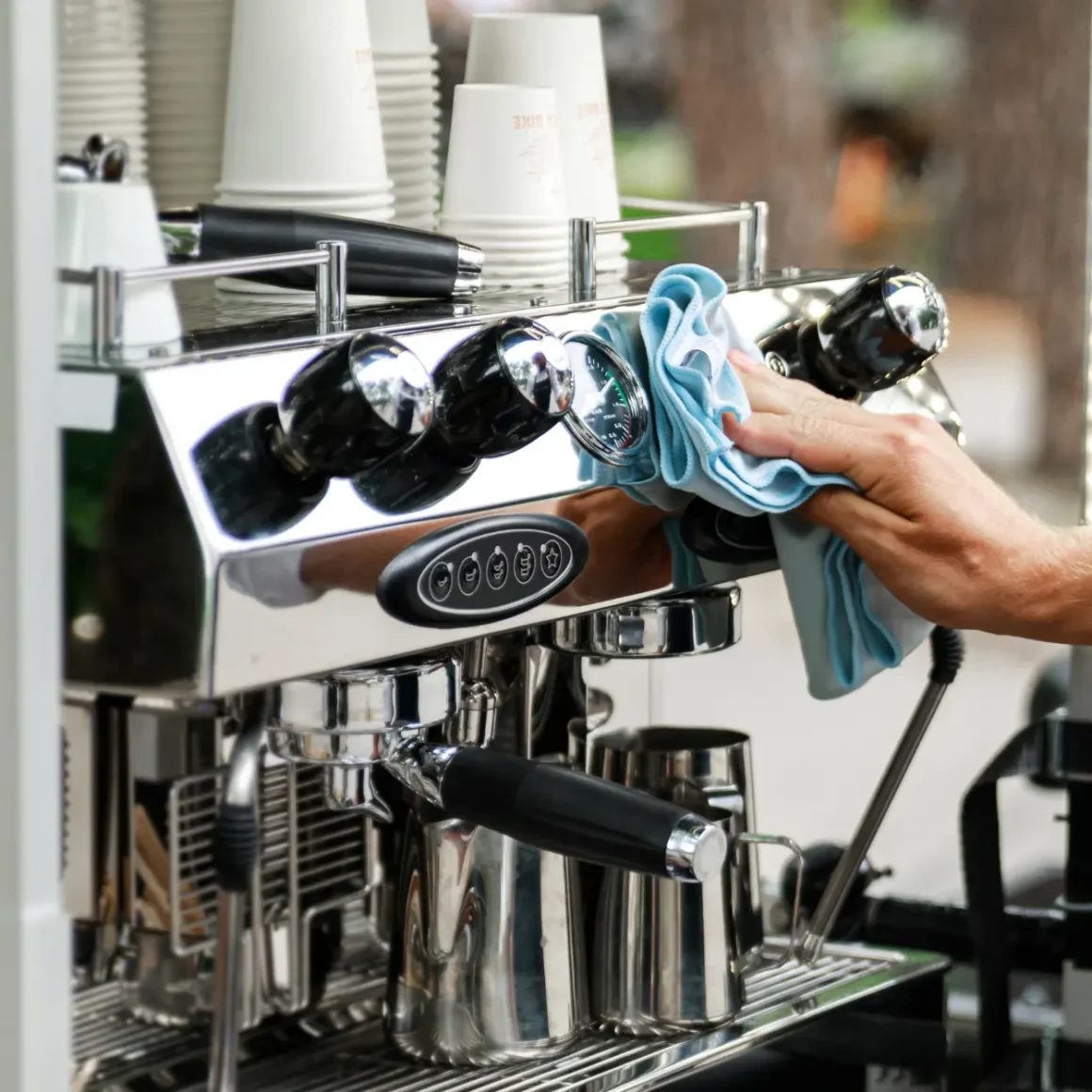 a person cleaning an espresso machine
