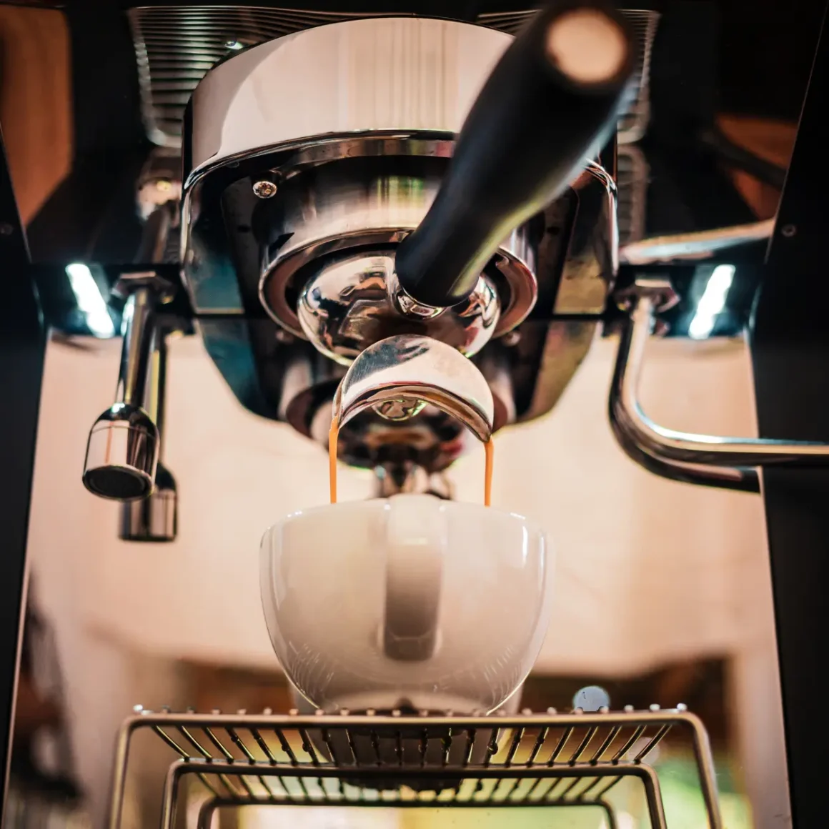 an espresso machine pouring coffee into a cup