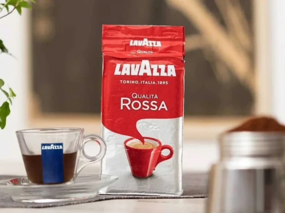a bag of qualita rossa lavazza coffee next to a cup of coffee