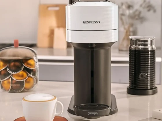 a nespresso vertuo next coffee maker with a white cup on a table