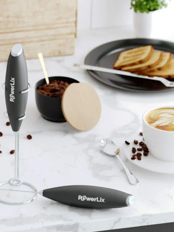 a powerlix milk frother pro and coffee cup with spoons and food on a plate