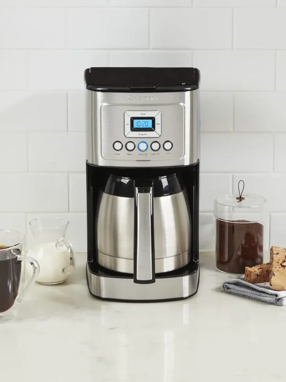 a cuisinart stainless steel 12-cup coffee maker and coffee mugs on a counter