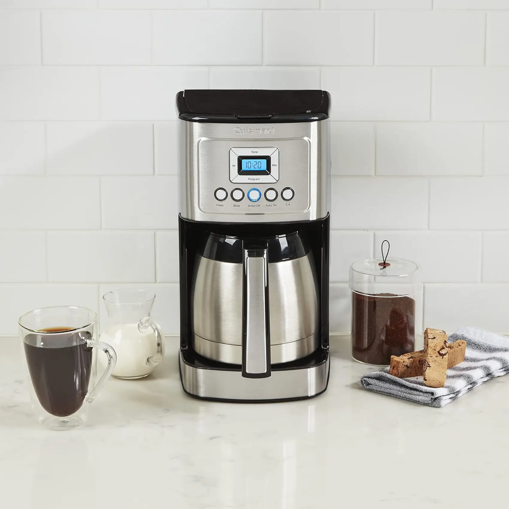 a cuisinart stainless steel 12-cup coffee maker and coffee mugs on a counter