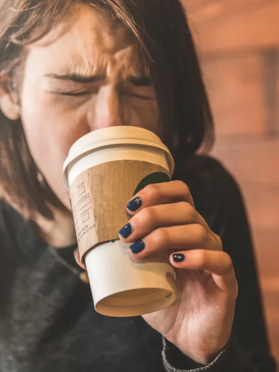 a woman drinking coffee from a cup