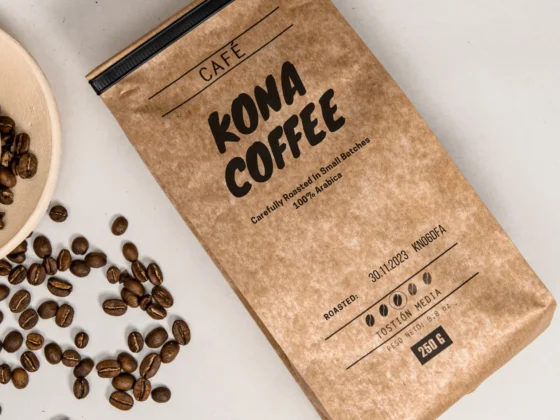 a bag of roasted kona coffee next to a bowl of coffee beans
