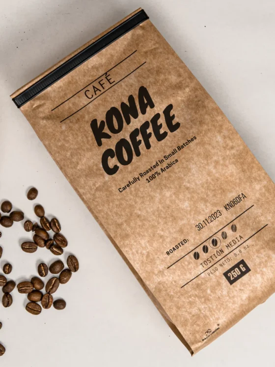 a bag of roasted kona coffee next to a bowl of coffee beans