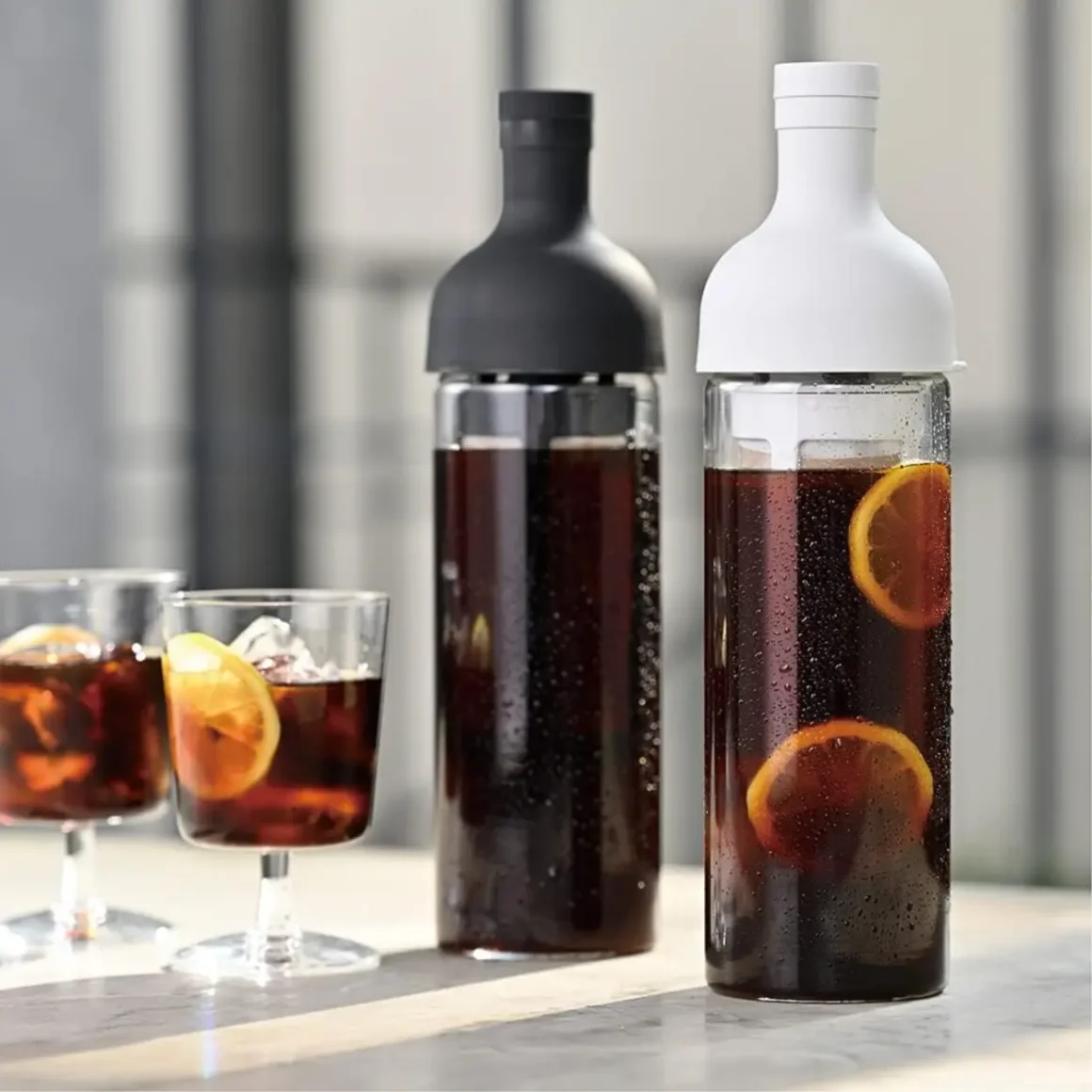 a hario coffee cold brew bottle with a couple glasses of coffee