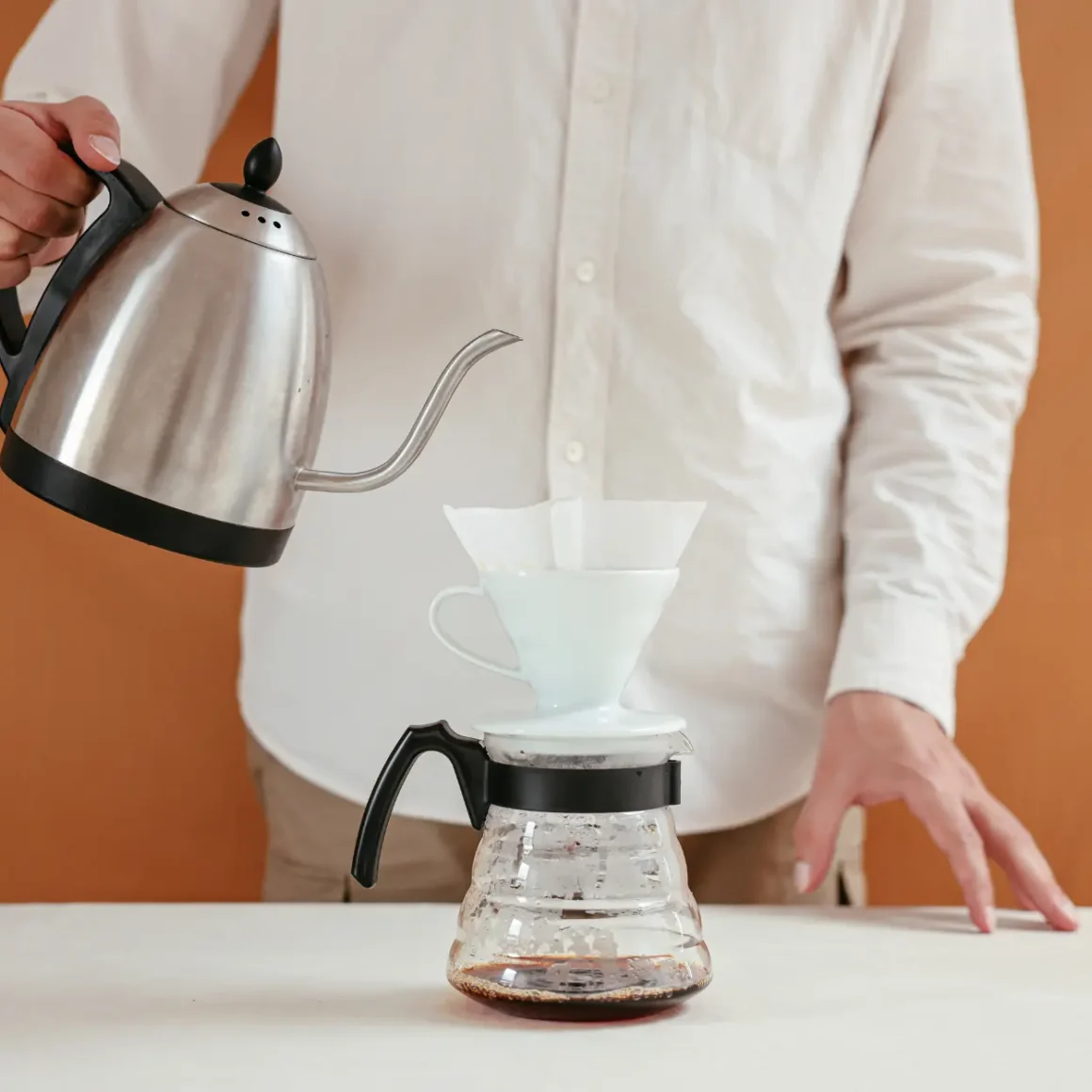 barista pouring coffee into a hario v60 pour-over coffee maker