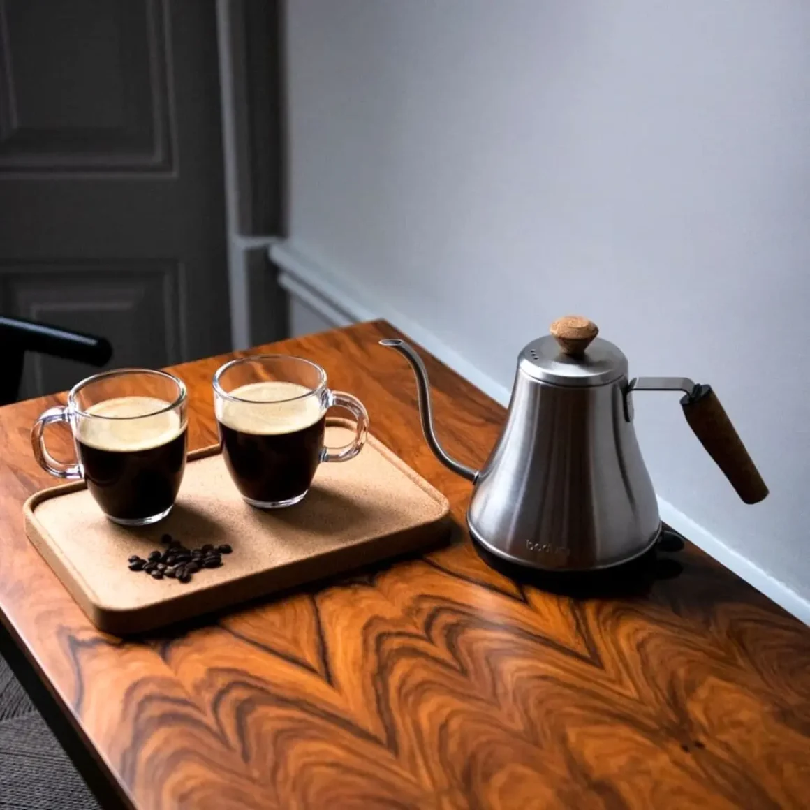 a water kettle and cups of coffee on a table