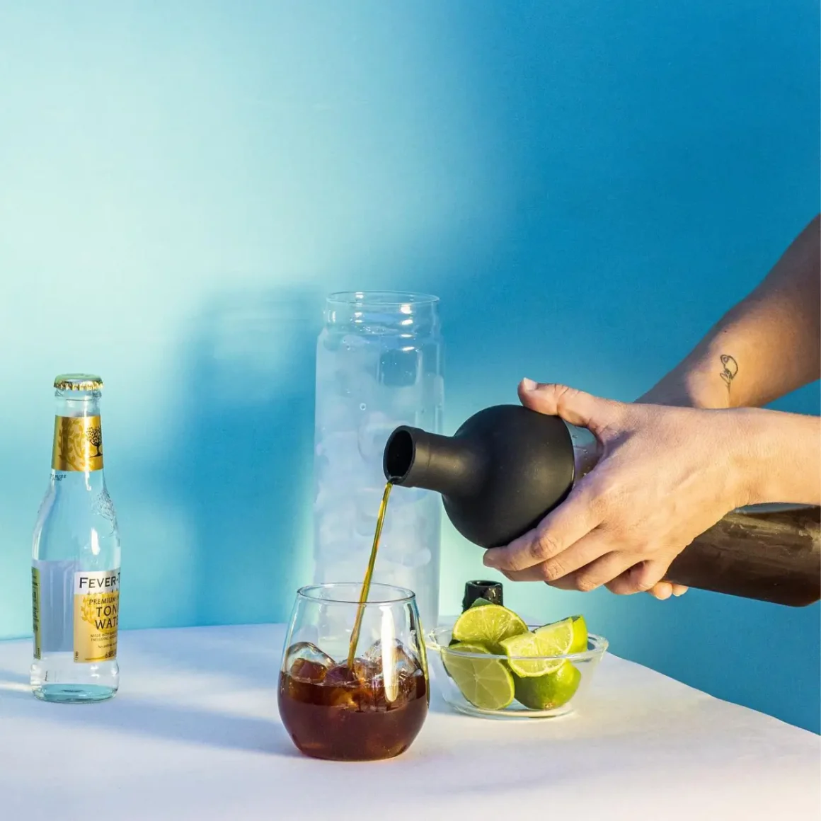 a person pouring coffee into a glass