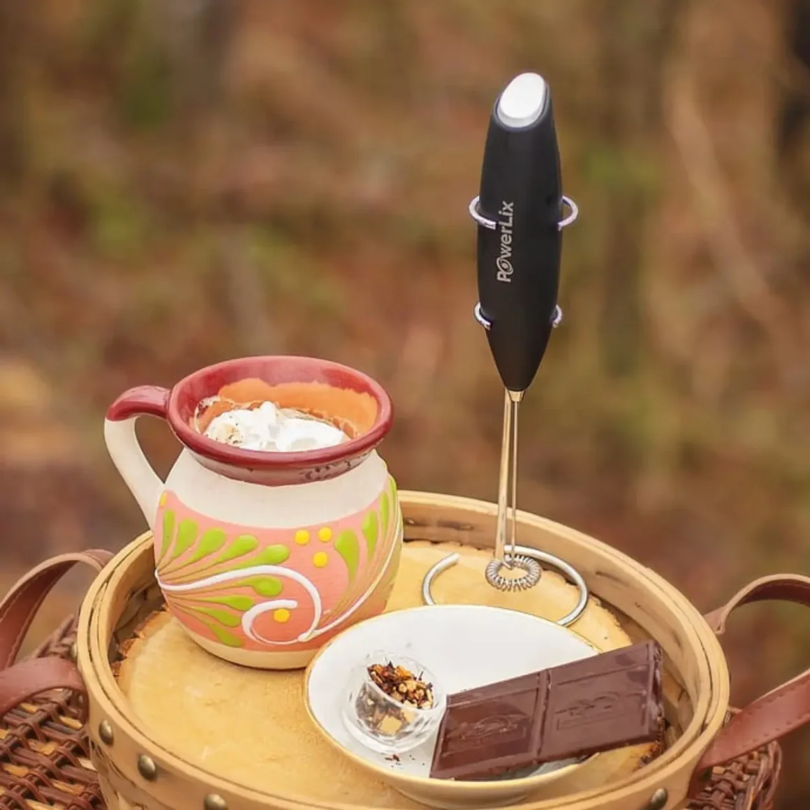 a basket with milk and powerlix frother and a chocolate bar