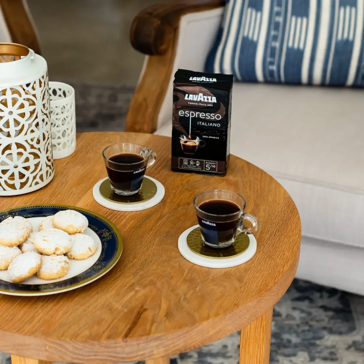 two cups of lavazza espresso italiono coffee and cookies on a table