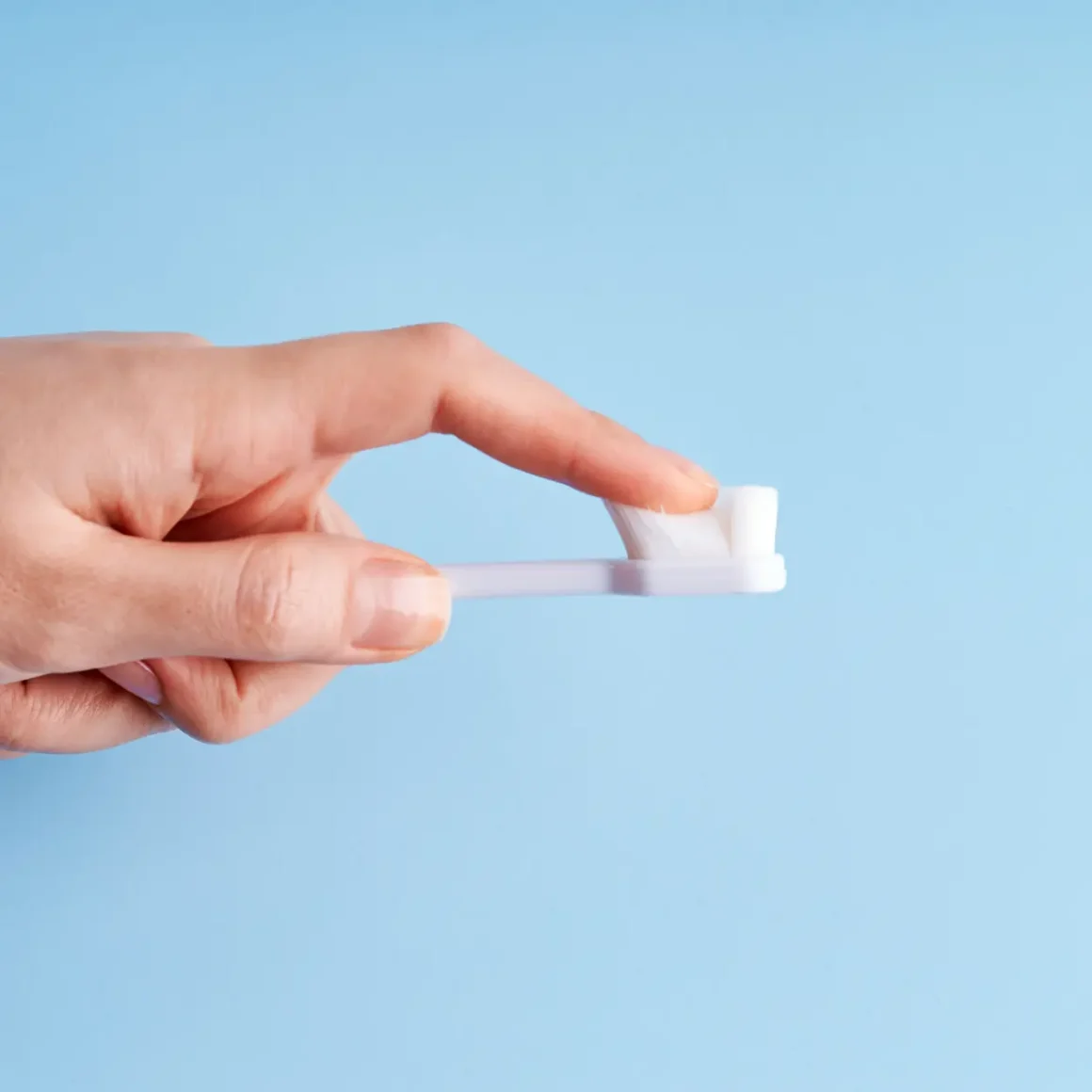 a hand holding a toothbrush