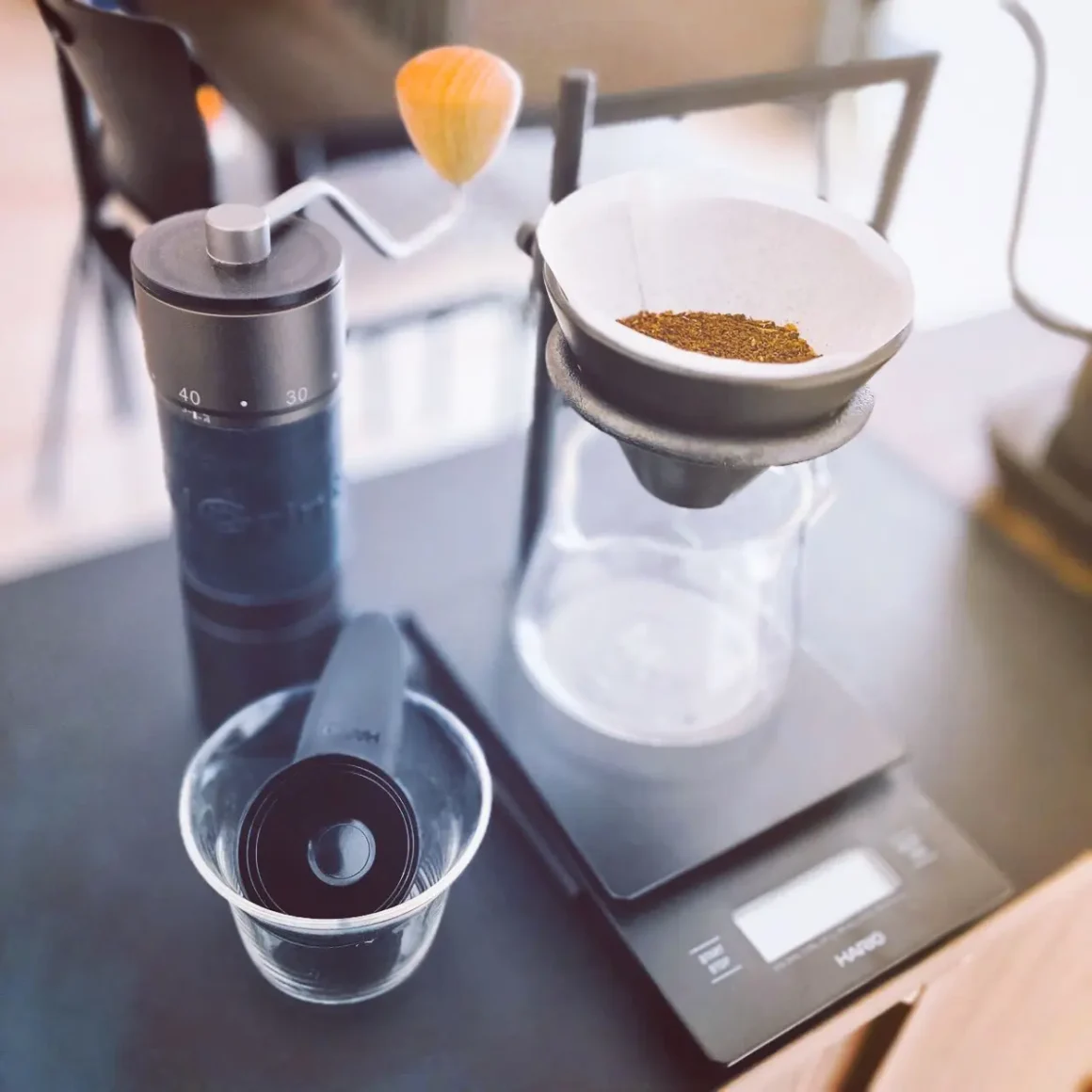 a kingrinder k6 coffee grinder and coffee beans on a scale