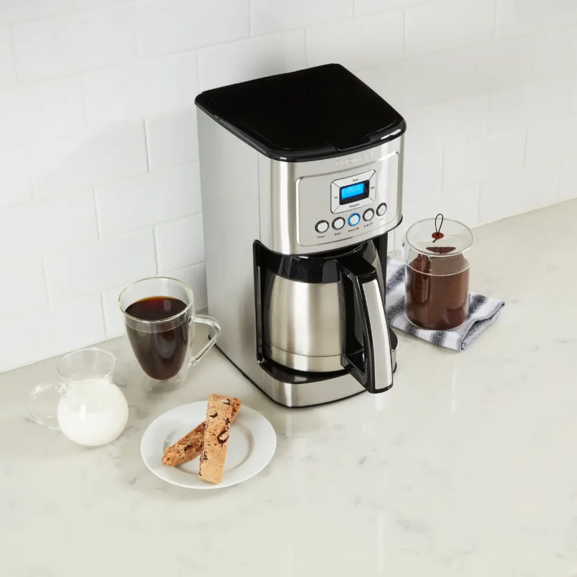 a cuisinart stainless steel 12-cup coffee maker and a plate of chocolates and milk