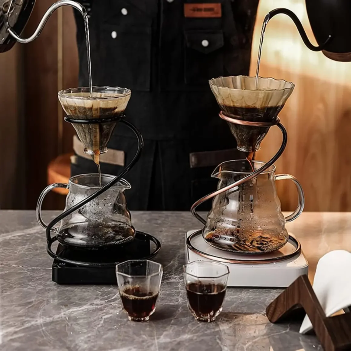 barista pouring water into filter on metal pour-over coffee stand