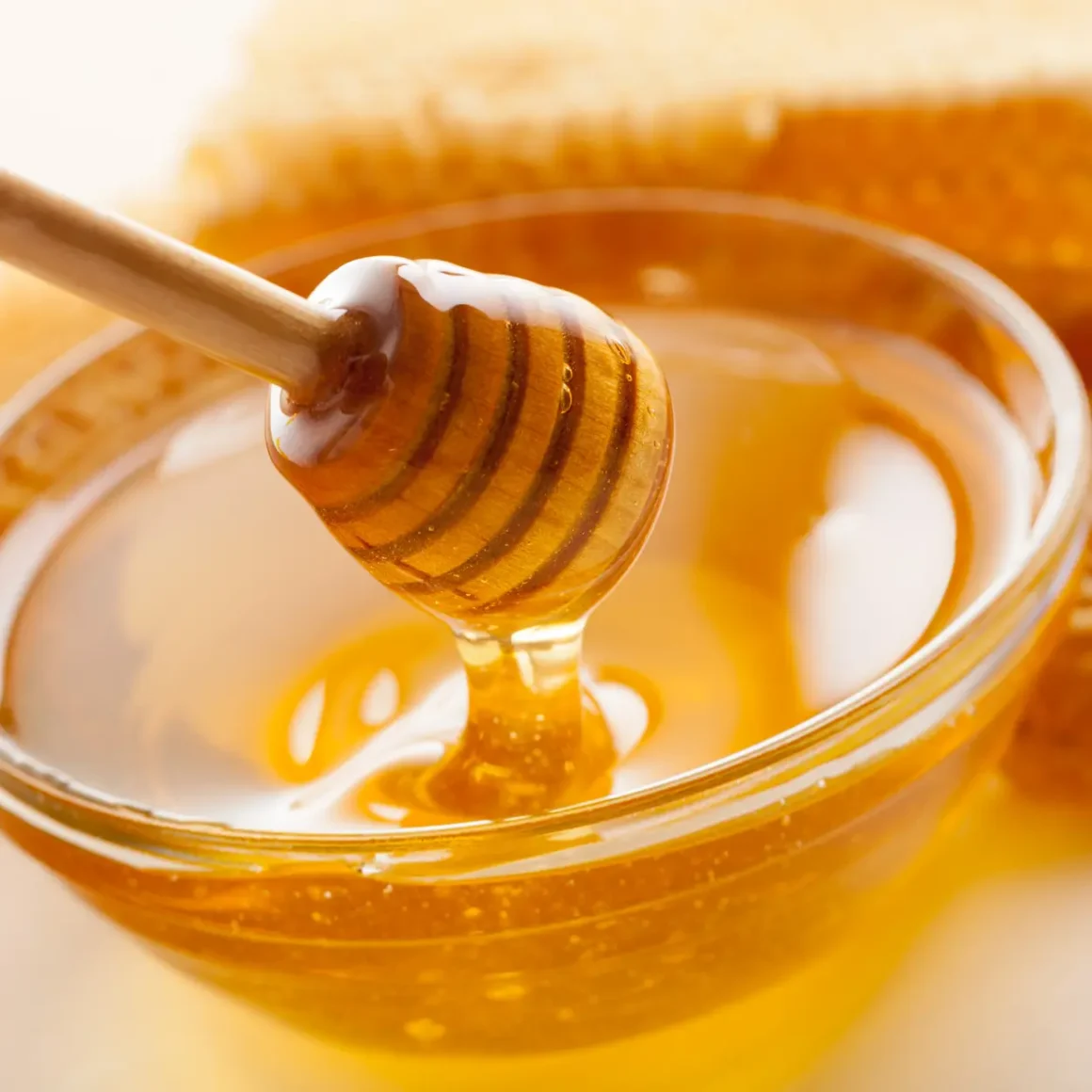 a honey dipper in a bowl of honey